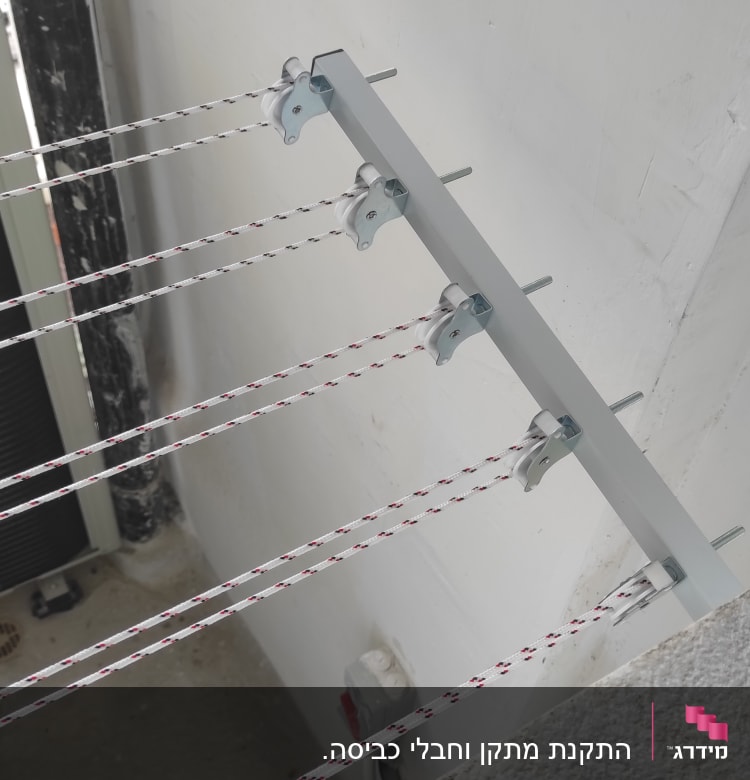 חבלי כביסה מותקנים על קיר עם תופסנים מתכתיים